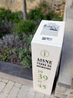 Borne mémorielle avec l'inscription "Aisne Terre de Mémoire 1939-1945" avec une plaque d'information sur la face supérieure.