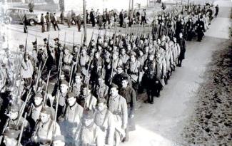 Défilé de volontaires étrangers engagés dans l’armée française en 1940, soldats en rang avec fusils