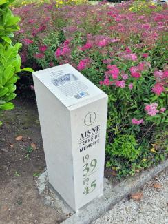 Borne Aisne Terre de Mémoire installée près d’un massif fleuri au monument du 23e Régiment de marche volontaire étranger (RMVE), inaugurée le 8 juin 2026