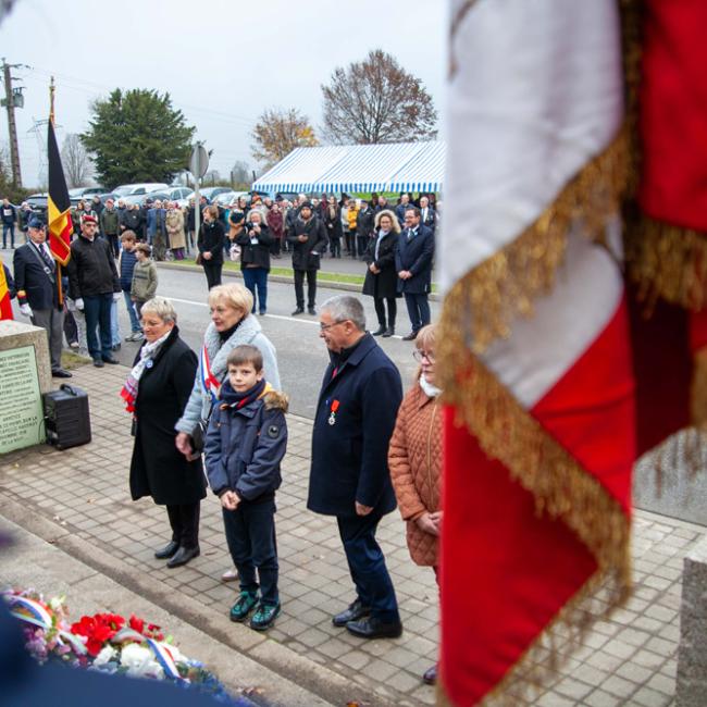 Elus se recueillant, porte-drapeaux et public en arrière plan