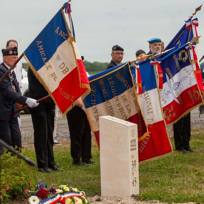 Porte-drapeaux rassemblés autour de la borne Aisne Terre de Mémoire avec gerbes de fleurs déposées à Flavy-le-Martel, lors de la cérémonie du 31 mai 2026