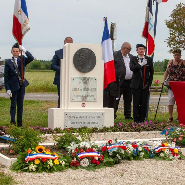 Monument dédiée au général Leclerc à Flavy-le-Martel, entourée de nombreuses gerbes de fleurs et de porte-drapeaux lors de la cérémonie du 31 mai 2026