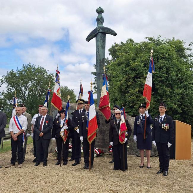 Groupe de porte-drapeaux et représentants officiels devant le monument commémoratif et la borne Aisne Terre de Mémoire à Leuilly-sous-Coucy le 7 juin 2026